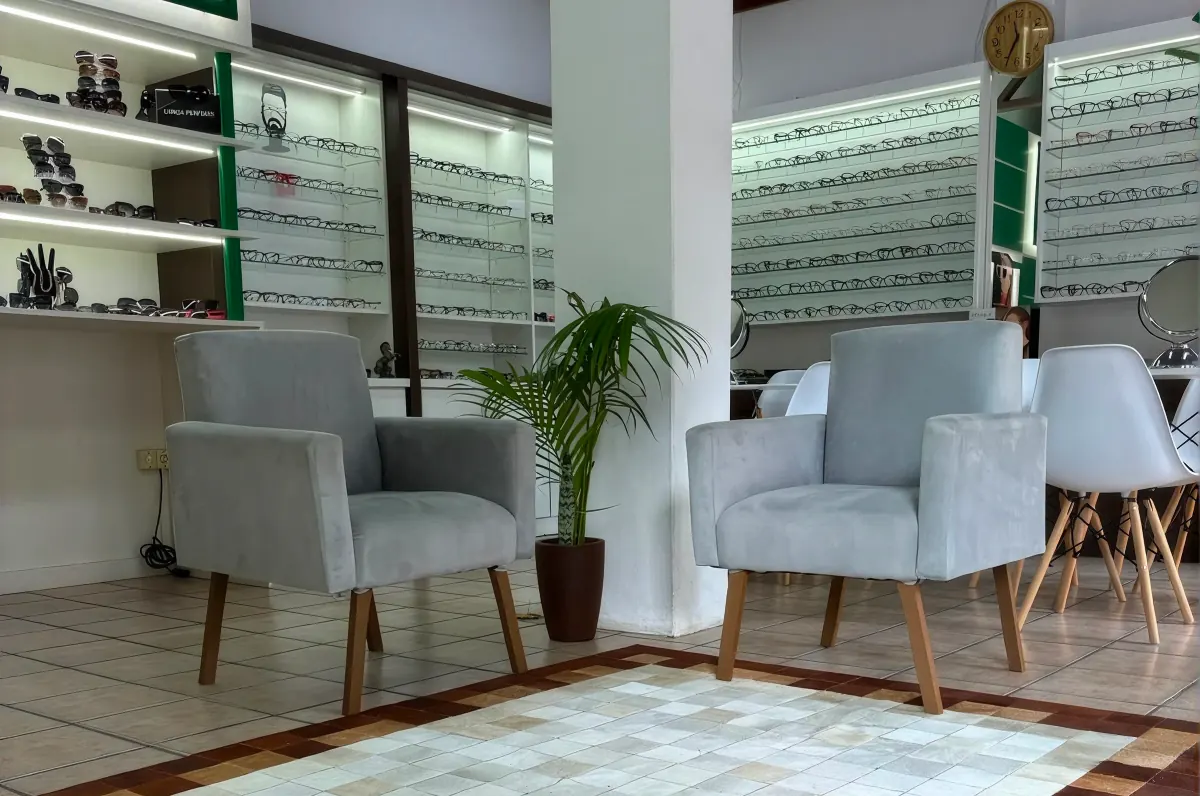 Espaço de atendimento da MP Óptica com poltronas e expositores